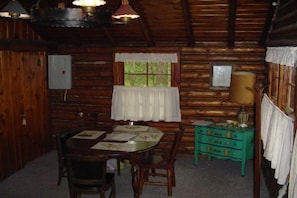 Cozy cabin interior with a wooden dining table, chairs, and dresser.