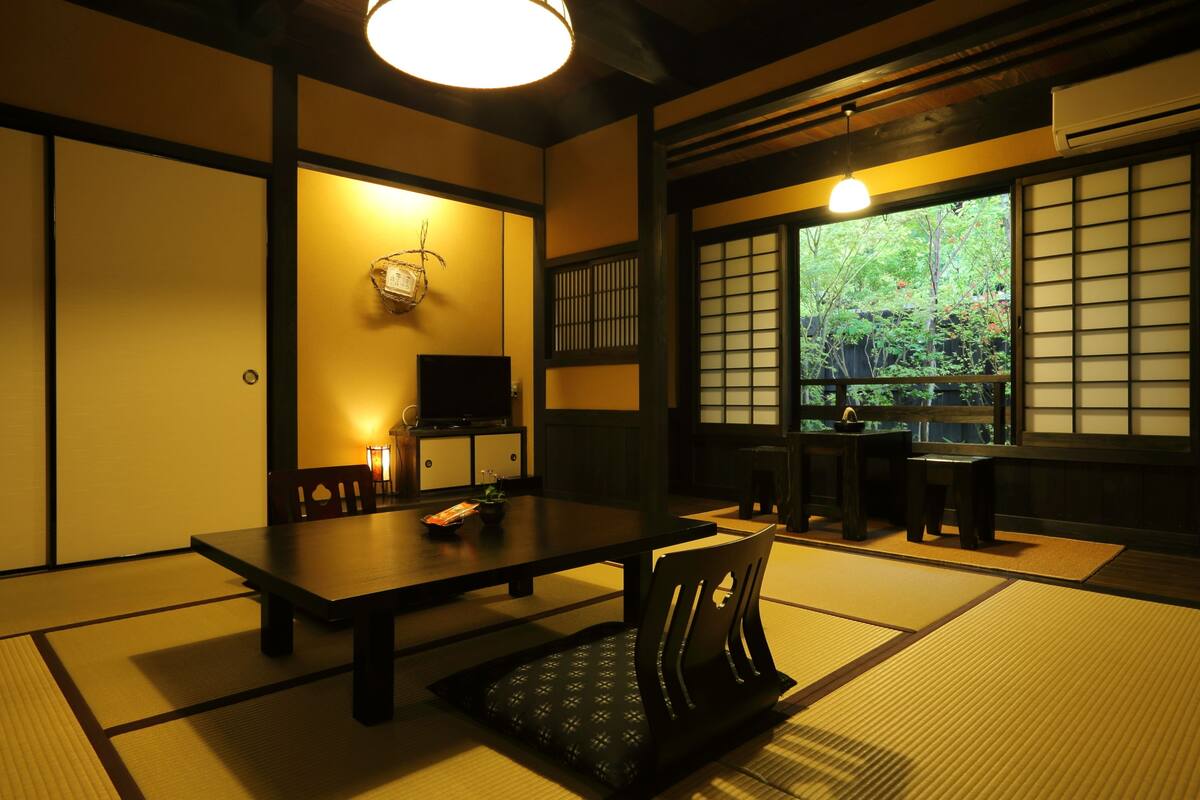 Une pièce de style japonais traditionnel, avec un sol recouvert de tatamis, une table basse et des portes coulissantes.