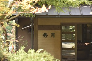 A traditional Japanese building with a wooden exterior and a sign with Japanese characters. - Shugetsu (Kokonoe)