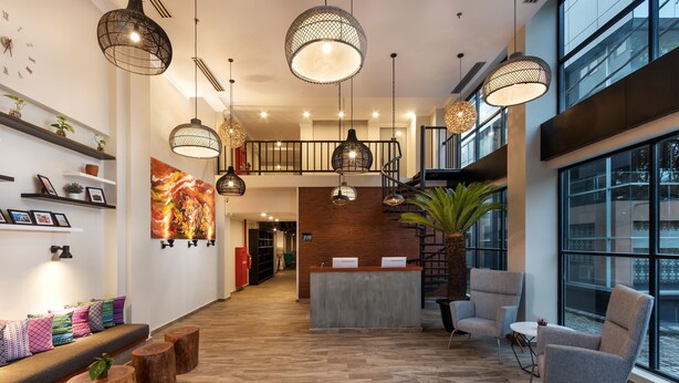 Eine geräumige Lobby mit Empfangstresen, Sitzgelegenheiten und großen Fenstern mit Blick.