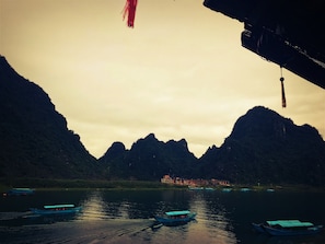 A river with boats and a mountainous landscape in the background. - Phong Nha Coco House (Phong Nha)
