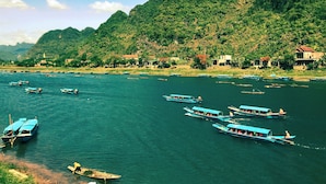 A river with boats and houses along the banks. - Phong Nha Coco House (Phong Nha)
