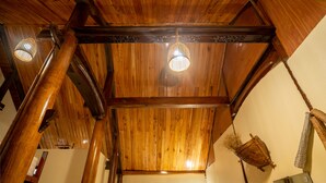 A wooden ceiling with exposed beams and a hanging light fixture. - Phong Nha Coco House (Phong Nha)