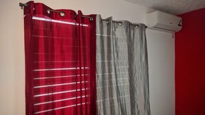 A bathroom with a red and grey shower curtain, a white wall, and a red wall. - Modern New Kingston Apartment (Secured/Parking) (Kingston)