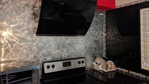 A kitchen with a stainless steel range hood, a built-in oven, and a microwave. - Modern New Kingston Apartment (Secured/Parking) (Kingston)