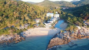 Une station balnéaire comprenant plusieurs bâtiments, une plage et une rivière.