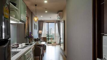 A modern kitchen with a built-in oven, a coffee machine, and a dining area with a view of the city.