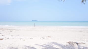 Di pantai, kursi berjemur, payung pantai, dan handuk pantai