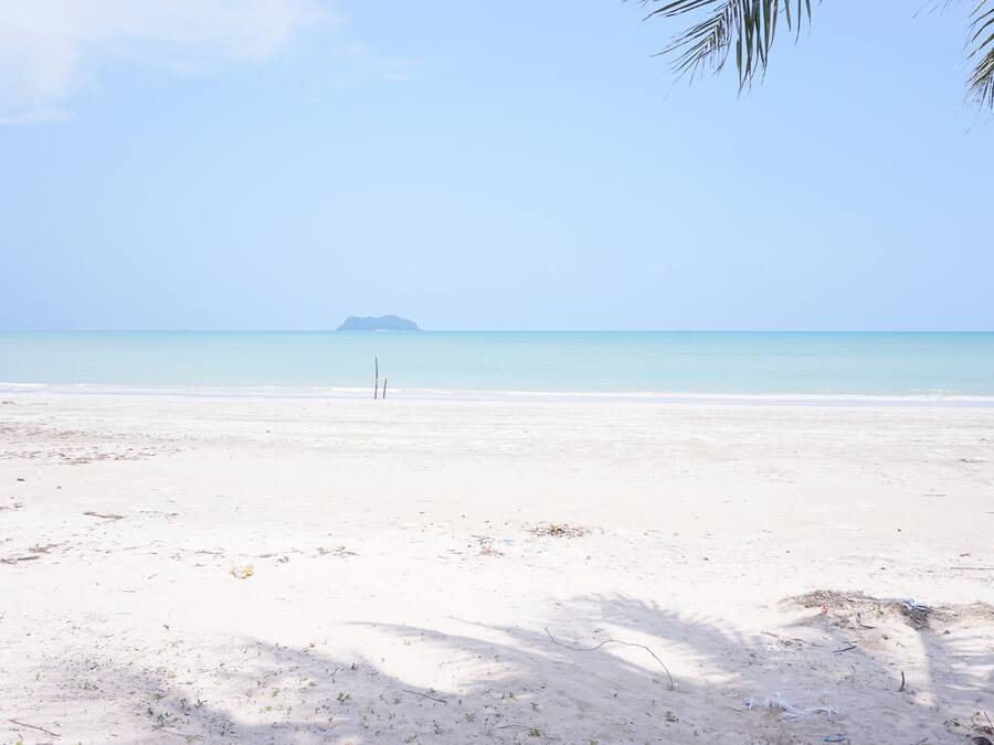 En la playa, sillas reclinables de playa, sombrillas, toallas de playa