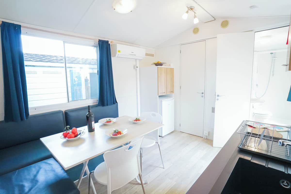 A compact kitchen with a dining area, a built-in oven, and a sink.