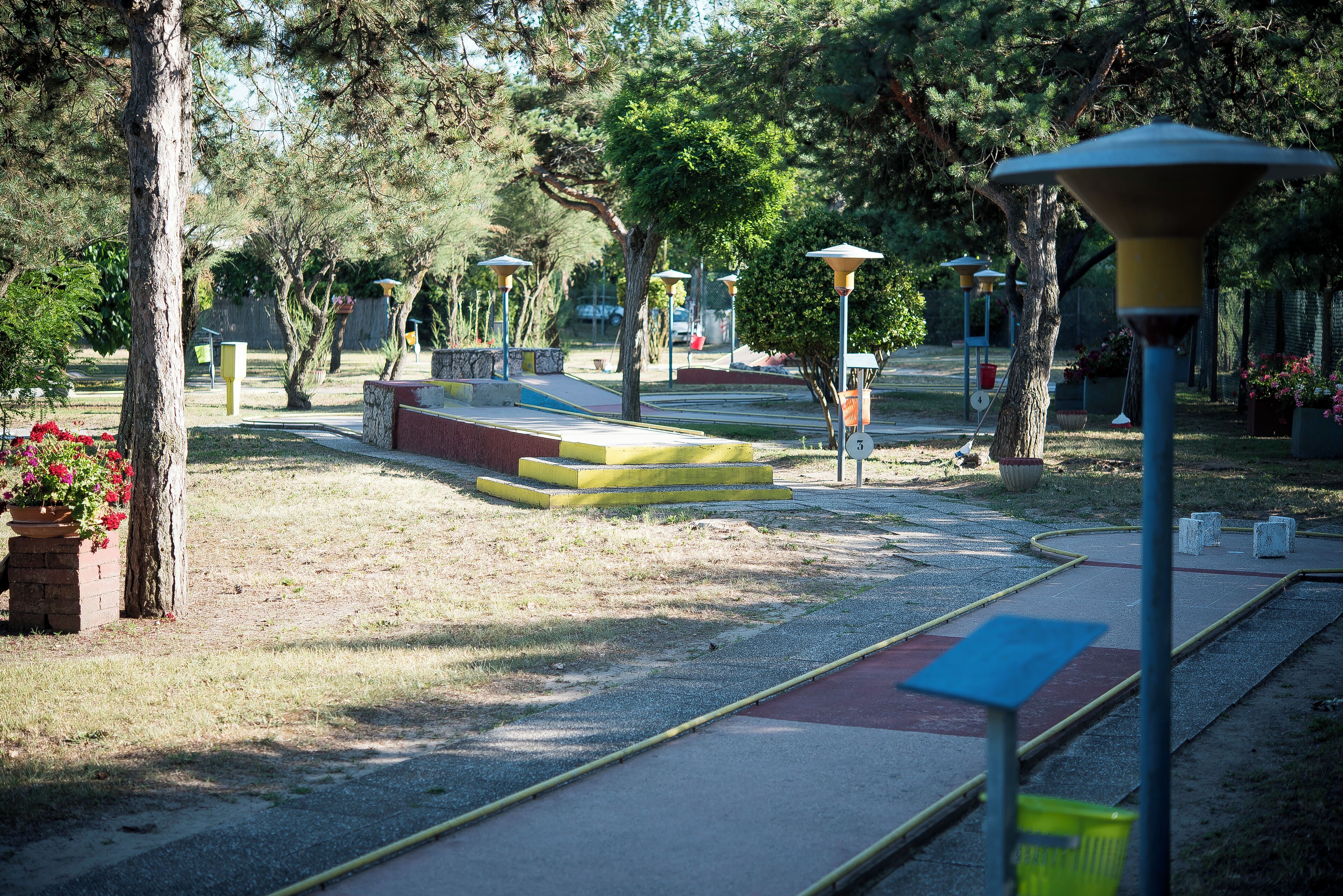 Un parque con senderos, bancos y farolas.