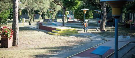 Un parque con senderos, bancos y farolas.