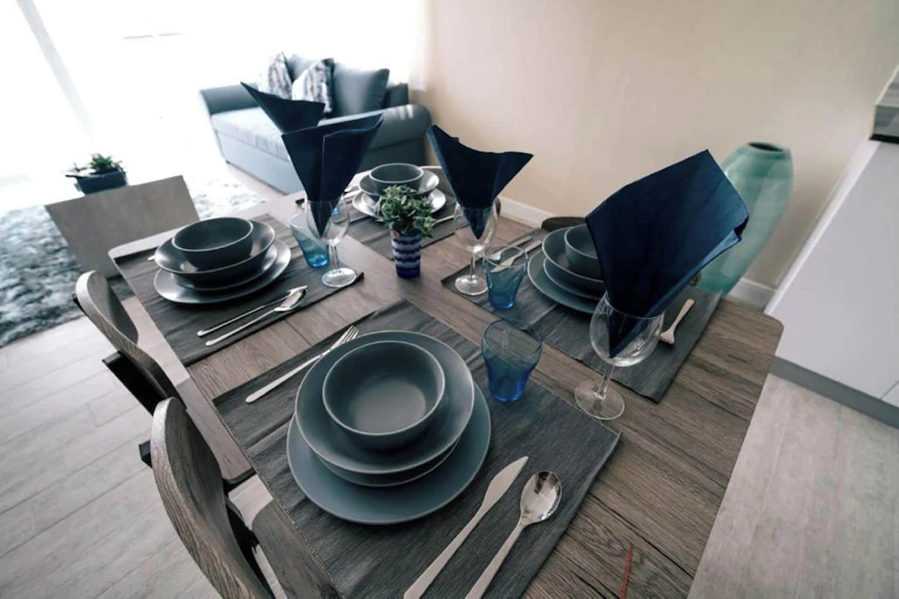 A dining table set with plates, glasses, and cutlery.