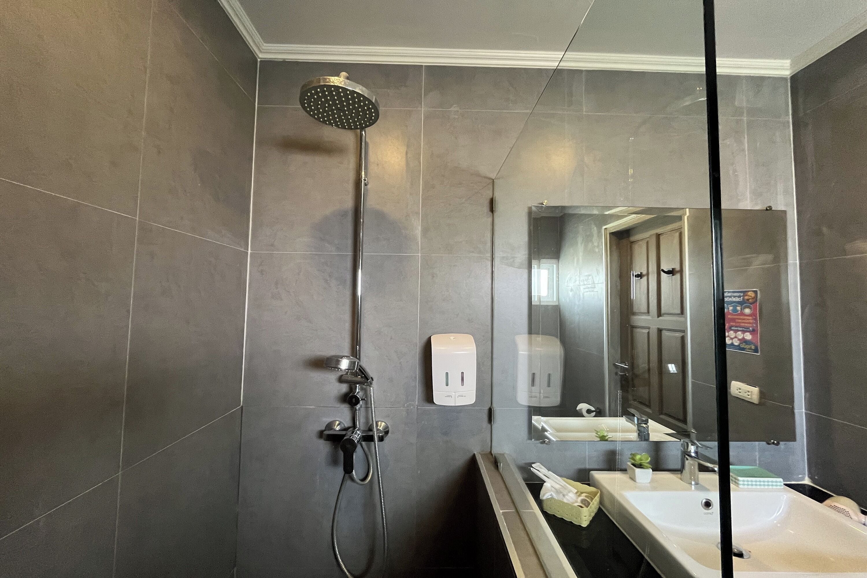 Un baño moderno con ducha, lavamanos y espejo.