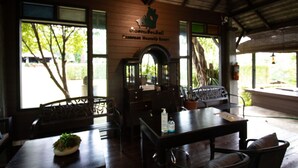 Un interior de madera con un mostrador de recepción, una sala de estar y un letrero que dice "Emanuel Huanuhi Resort".