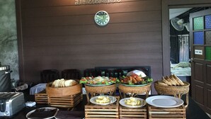 Un bufé de desayuno con diferentes alimentos y un reloj en la pared.