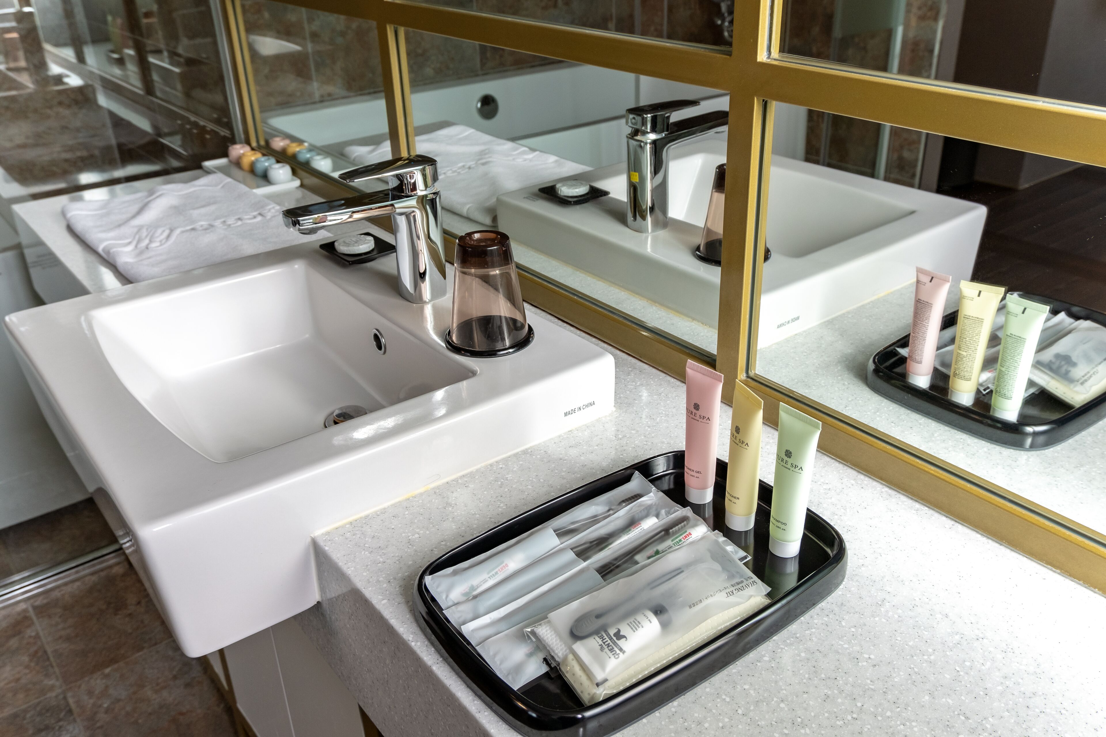Ein modernes Badezimmer mit zwei Waschbecken, einem Spiegel und Pflegeprodukten.