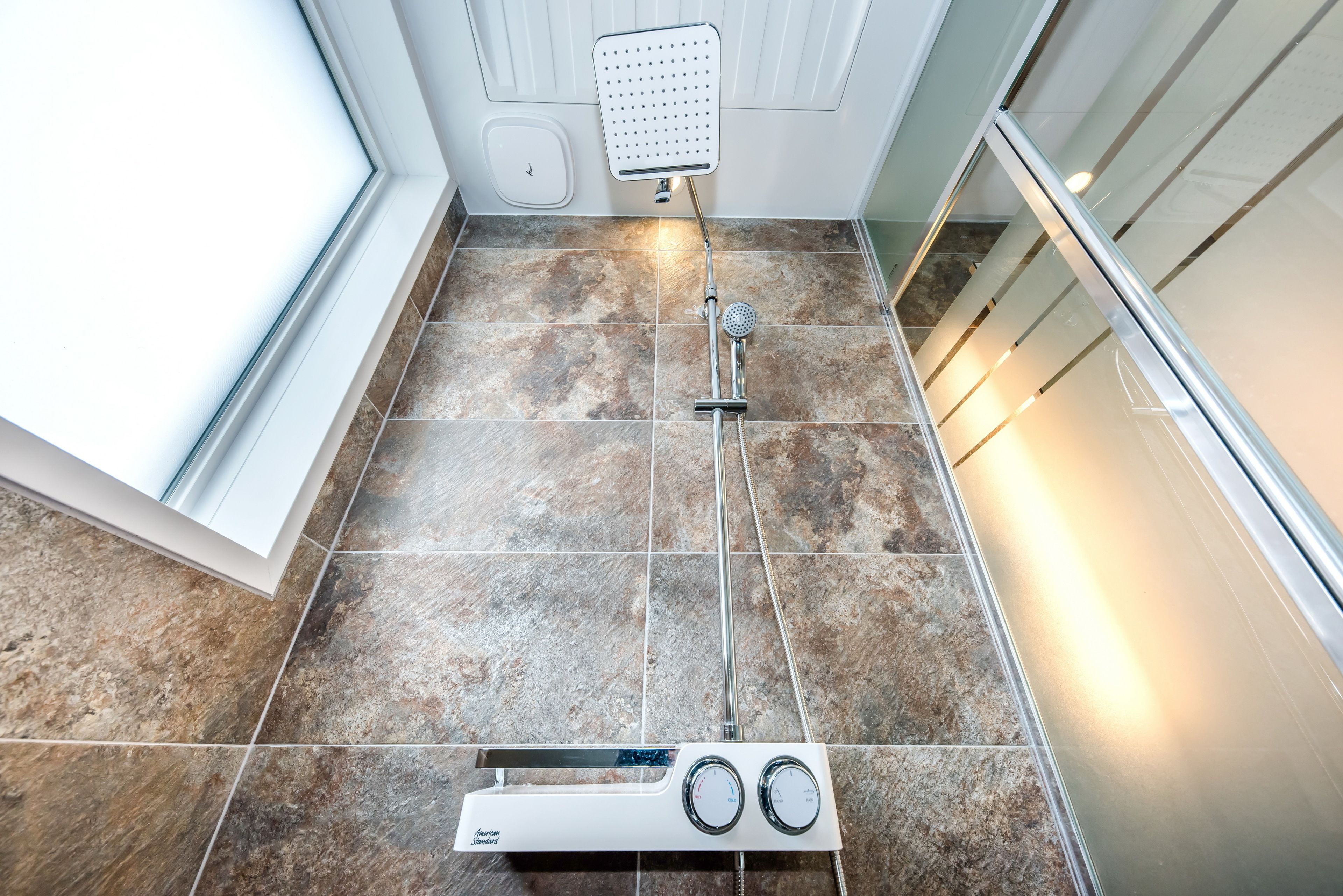 A bathroom with a shower, a toilet, and a bidet.