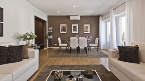 A modern living room with a dining area, featuring a sofa, coffee table, and dining table with chairs. - A modern apartment in Cascais Center (Cascais)