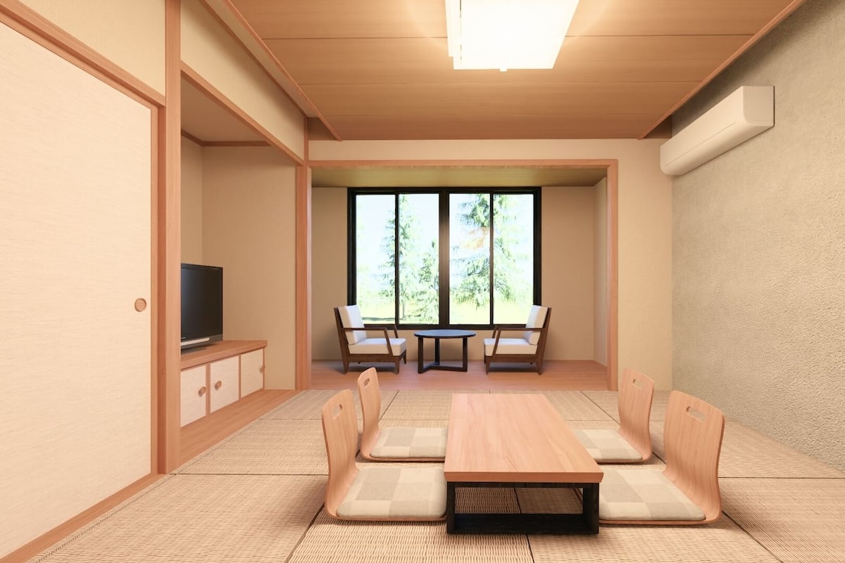 Una habitación con televisión, una mesa y cuatro sillas.