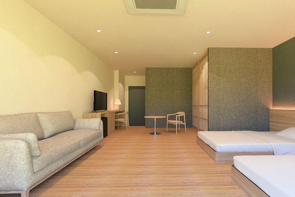 Una habitación de hotel moderna con sofá, cama, televisor, escritorio y una silla.
