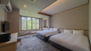 A hotel room with two beds, a desk, a chair, and a television.