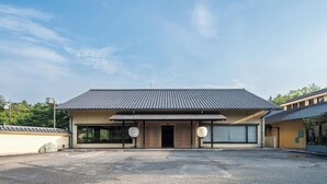 Un edificio con techo plano, entrada cubierta y estacionamiento.