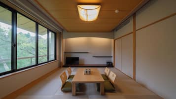 A traditional Japanese-style room with tatami flooring, a low table, and seating.