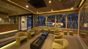 A modern lounge area with a sectional sofa, armchairs, ottomans, and a coffee table. - Terrace Kiyomizu Kyoto (Kyoto)