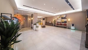 A spacious lobby with a reception desk, seating area, and a robot vacuum cleaner. - Homeinn Plus Hotel (Xi'an Gaoxin South Second Ring Fengqing Park Subway Station) (Xi'an)