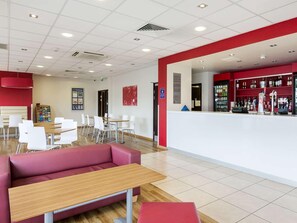 Un intérieur moderne comprenant un comptoir d’accueil, un espace détente et un bar.