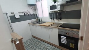 Una cocina compacta con microondas, fregadero y horno.