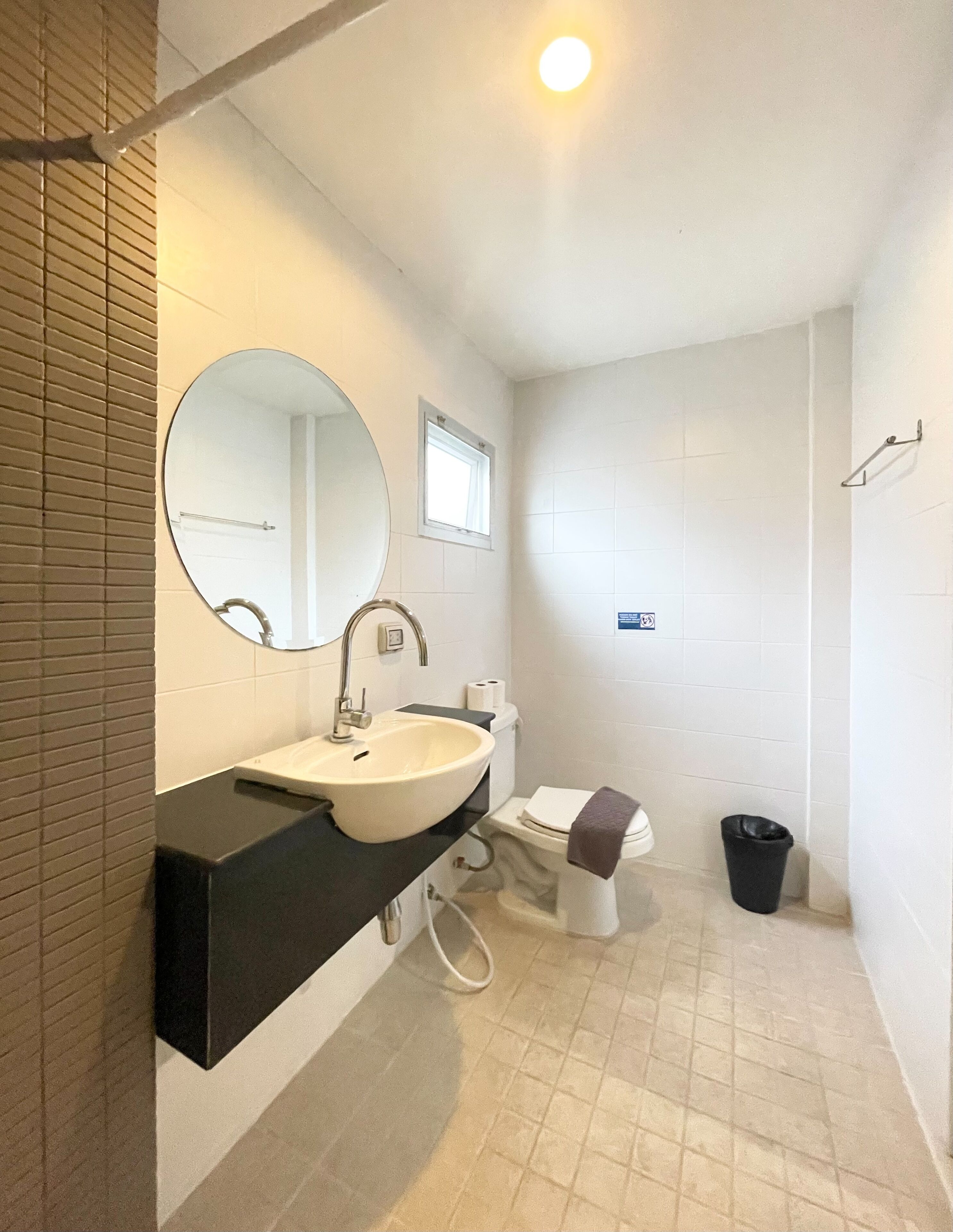 A modern bathroom with a white sink, mirror, and toilet.
