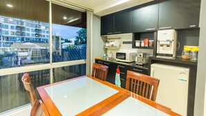A modern kitchen with a dining table and chairs, a refrigerator, microwave, and a coffee maker. - Hub53 Coworking & Coliving Space (Chiang Mai)