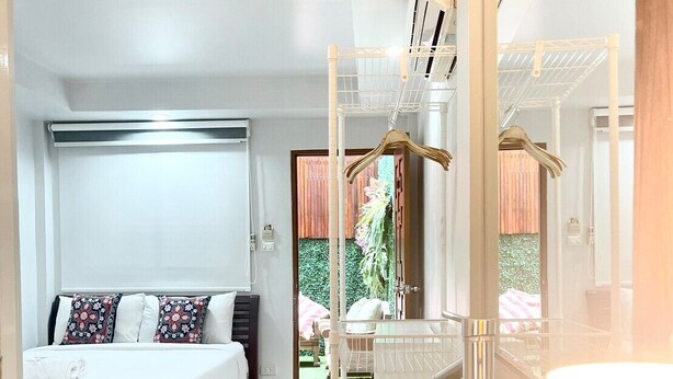 A modern bedroom with a bed, a hanging chair, and a large mirror. - Hub53 Coworking & Coliving Space (Chiang Mai)