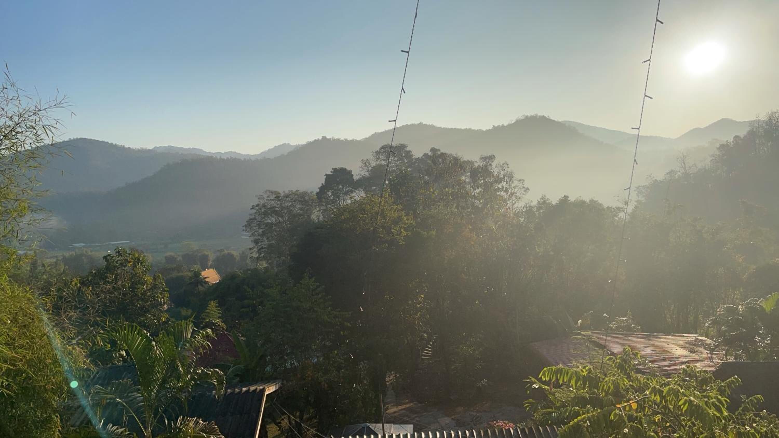Vista de un paisaje montañoso con cielo despejado y luz solar.
