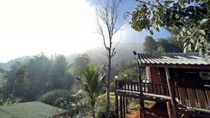Eine Holzhütte mit Balkon und Blick auf eine üppige Landschaft.