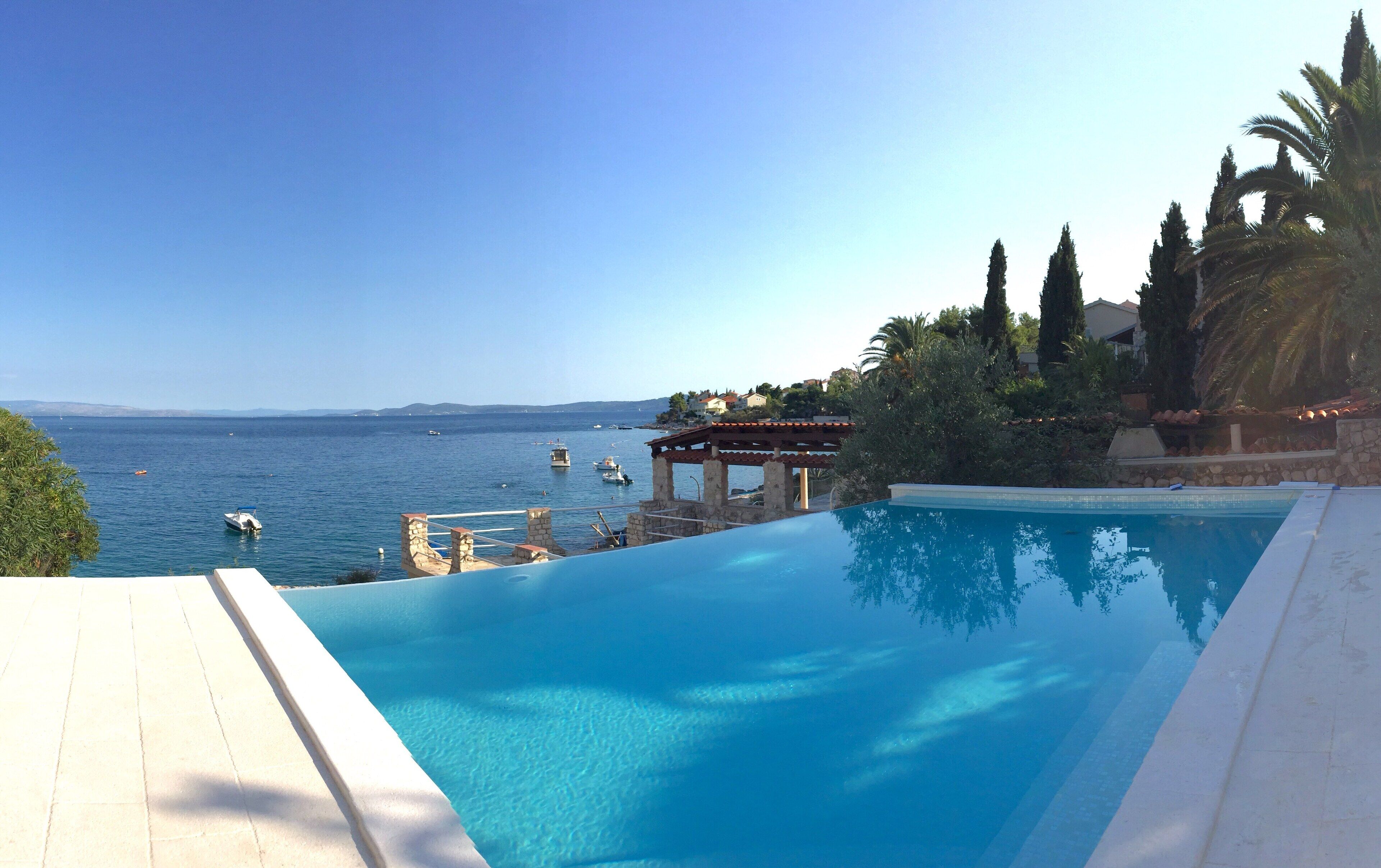 Una piscina con vistas al mar y un pabellón.