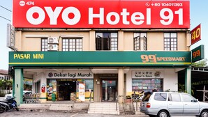 A building with a large red sign for OYO Hotel 91, a green storefront for PASAR MINI, and a SPEEDMART store. - Hotel O 91 @ Bukit Mewah (Kajang)