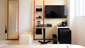 A compact hotel room with a bed, a desk with a flat-screen TV, a small refrigerator, and a coffee maker. - Center Hotel Narita 2 R51 (Narita)