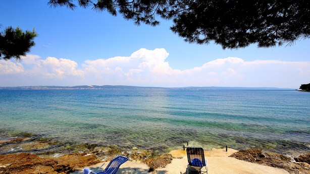 A beach with two beach chairs and a concrete path leading to the water. - Villa With Private Pool (Kukljica)