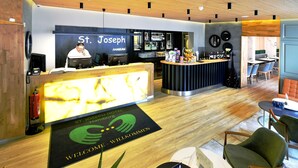 Ein Hotel-Rezeptionsbereich mit Empfangstresen, einer Bar und Sitzgelegenheiten.