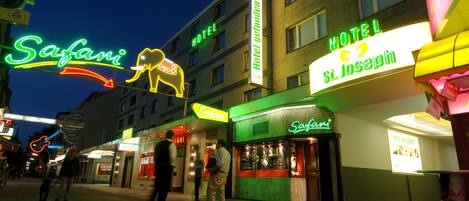 Un hotel llamado "Hotel St. Joseph" con un letrero de neón y un letrero de neón con forma de elefante.