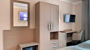 A hotel room with a bed, a desk with a chair, a TV, and a wardrobe. - St Joseph Hotel Hamburg Reeperbahn St Pauli Kiez (Hamburg)