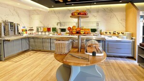 A modern kitchen with marble walls, a central island with a fruit display, and a coffee machine. - St Joseph Hotel Hamburg Reeperbahn St Pauli Kiez (Hamburg)