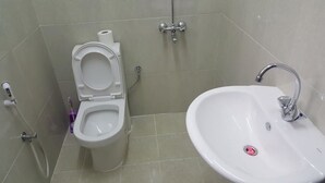 A bathroom with a toilet, bidet, and sink. - Today House Suites (Salalah)