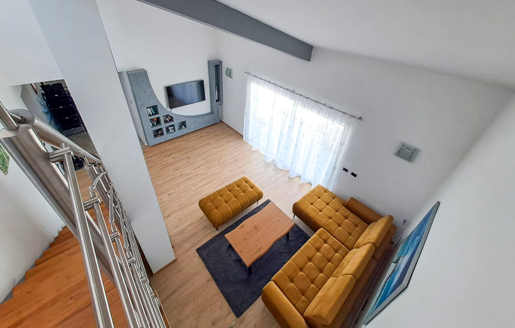 Un salon moderne avec un canapé, une table basse et un téléviseur.