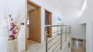 A modern interior with a staircase, wooden doors, and a decorative vase with dried flowers. - Cozy home in Galizana (Galizana)