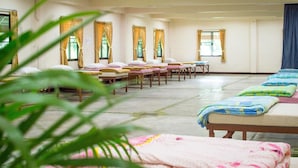 A hotel room with multiple beds, a large window, and curtains. - Pai Backpackers Paradise - Adults Only (Pai)
