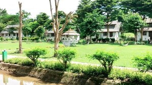 A traditional-style building with multiple rooms, a small garden, and a pond. - Pai Backpackers Paradise - Adults Only (Pai)